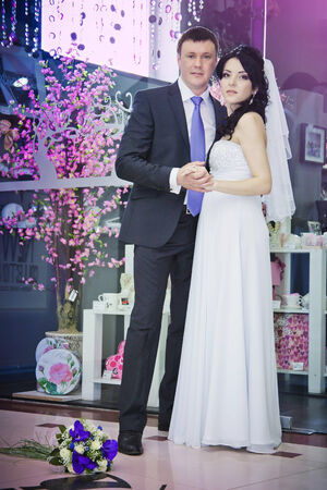 Beautiful bride and groom standing in a shopの写真素材