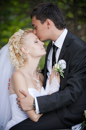 wedding: couple in love bride and groom together in bridal summer day enjoy a moment of happiness and love. Beautiful happy newlywed outdoors. handsome man and alluring woman in white dress on natureの写真素材
