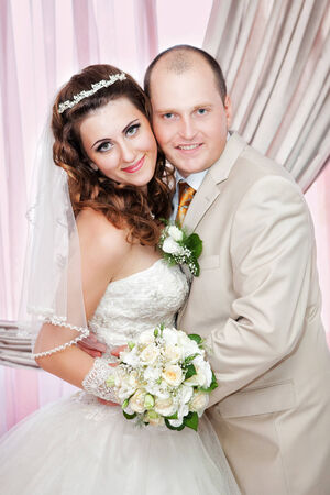 Portrait of the groom and the bride near a windowの写真素材