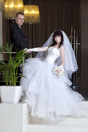 happy bride and groom in the modern hotel hallの写真素材