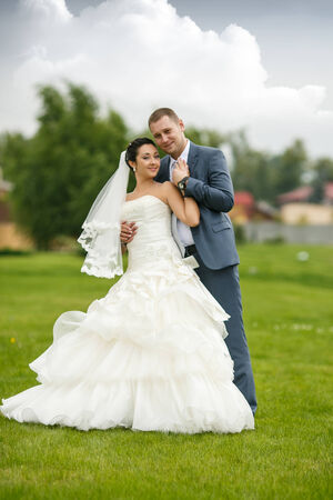 Elegant bride and groom posing together outdoors on a wedding dayの写真素材