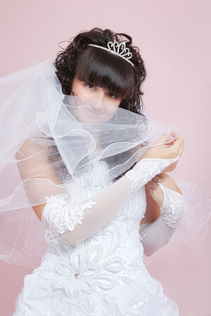 studio portrait of a happy bride on a pink backgroundの写真素材