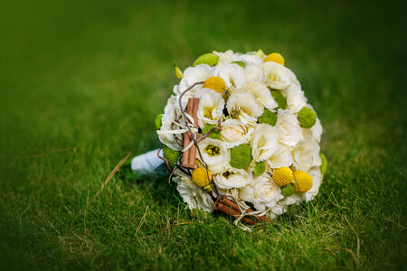 Wedding bouquet from beige roses, cinnamon, a lemon, a lime on a green grassの写真素材