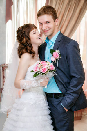 Portrait of the groom and the bride near a windowの写真素材