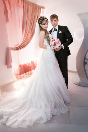 Portrait of the groom and the bride near a windowの写真素材