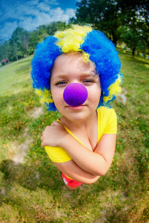 Funny girl in clown wig with blue noseの写真素材