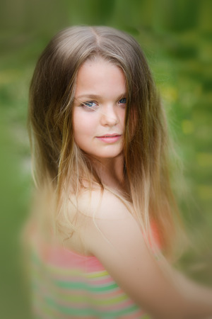 Young teenager portrait with natural green hedge background in a park.の写真素材