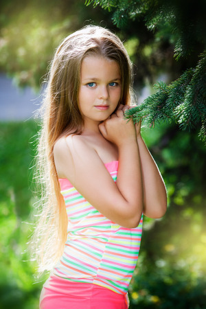 Young teenager portrait with natural green hedge background in a park.の写真素材