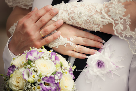 Hands and rings on wedding bouquetの写真素材
