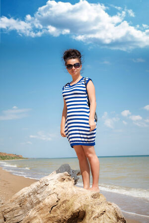 Young woman walking on the beach in the sand in a nice summer dayの写真素材