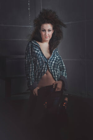 beautiful young brunette model wearing jeans, studio shotの写真素材