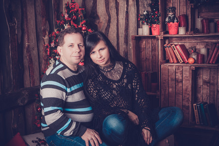 Loving couple smiling beside their christmas tree at homeの写真素材