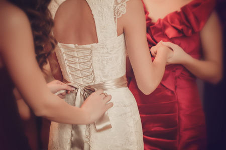 Bride is  putting on her white wedding dressの写真素材