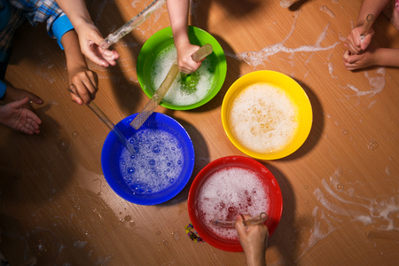 Children are blowing soap bubbles on the tableの写真素材