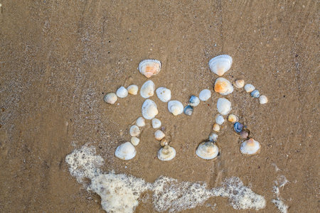 drawing on the sand couple in love made by seashells