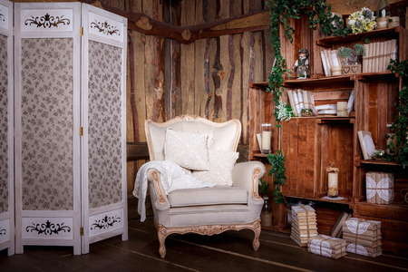 Wooden living room with beige chair and bookcaseの写真素材