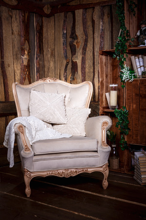 Wooden living room with beige chair and bookcaseの写真素材