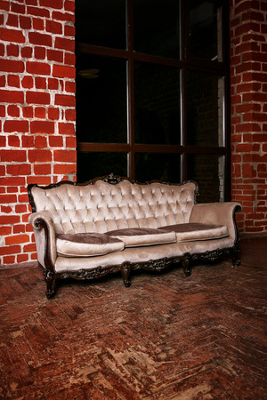Living room with beige sofa on the  red brick wall backgroundの写真素材