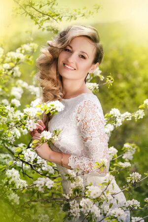 Portrait of a beautiful blonde woman in a blossoming gardenの写真素材