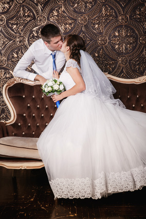 Kiss of the groom and bride in studioの写真素材