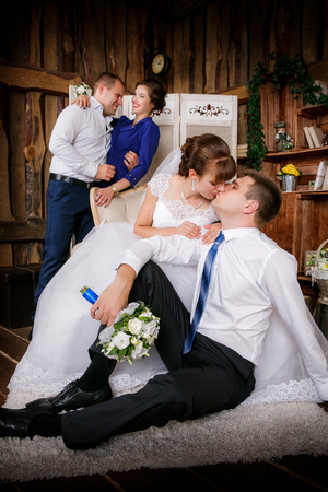 Happy groom, bride, groomsman, bridesmaid are in the room with a beautiful interiorの写真素材