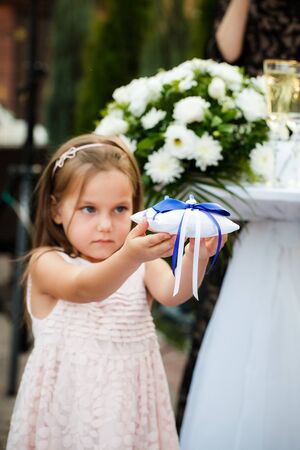 The girl holds a pillow with wedding rings during a wedding ceremonyの写真素材