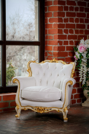 White leather armchair near windowの写真素材