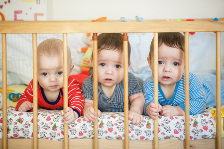 Portrait of  newborn triplets in the bedの写真素材