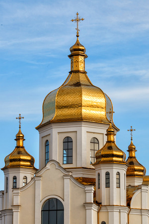 Gilded domes of orthodox Christian church shine on the blue sky background の写真素材