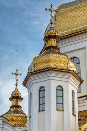 Gilded domes of orthodox Christian church shine on the blue sky backgroundの写真素材