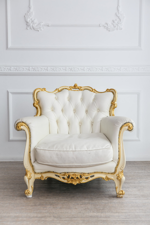 White leather wood armchair with golden decor in a white  living roomの写真素材