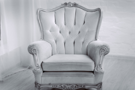Beige leather wood armchair with golden decor in a white living roomの写真素材
