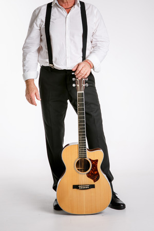 An elderly man is standing with guitar  isolated on white backgroundの写真素材
