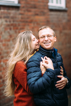 Loving couple of tourists walking around old town. Couple of lovers leisurely stroll in the cool autumn morning on the streets of a Lubeck (Germany).The guy holds his wife. Vacation, autumn, holiday, tourism: concept.の写真素材