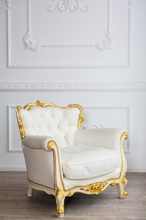 White leather wood armchair with golden decor in a white  living roomの写真素材