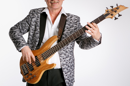 Senior is playing a bass guitar  isolated on white backgroundの写真素材