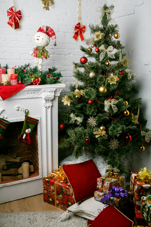 Image of chimney and decorated Christmas tree with giftの写真素材