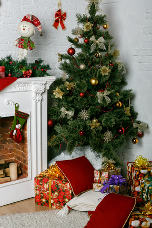 Image of chimney and decorated Christmas tree with giftの写真素材