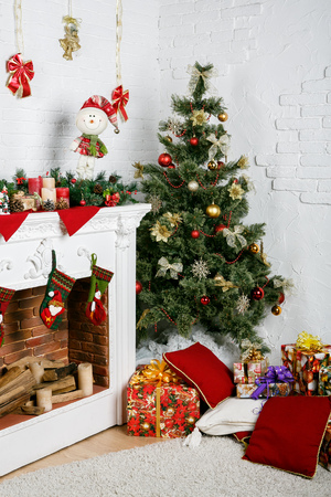 Image of chimney and decorated Christmas tree with giftの写真素材