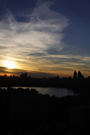 View of the central park reservoir in central park and new york city during a sunsetの写真素材