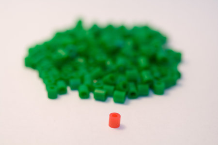 red plastic bead among many green beads