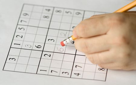 sudoku puzzle and hand erasing, focus on mistakeの写真素材