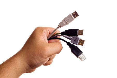 Hand holding bunch of computer cables isolated on white. Focus on connectors. Concept of beeing...