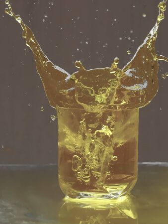 Ice cubes splashing into glass of tea  with Background blurの写真素材