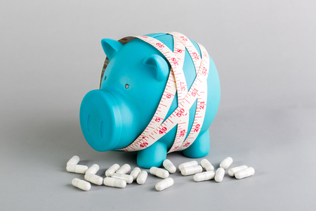 blue piggy bank with diet supplement for diet conceptの写真素材