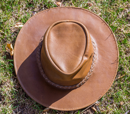 A brown cowboy hat rests on fresh grass in sunny weather.の写真素材