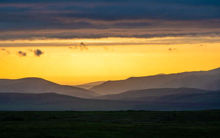 Dramatic sunset in Aksu Zhabagly Reserve. Fairytale evening dark panorama landscape.の写真素材