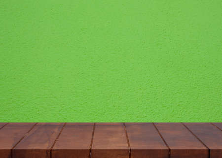 Empty wooden floor.Cement green wall background. There is an empty space for productionsの写真素材