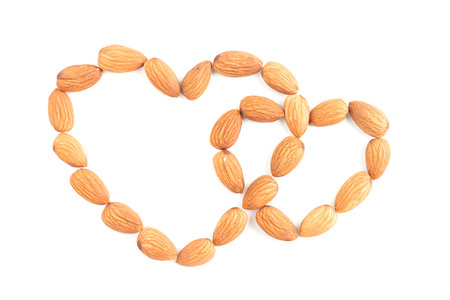 group almonds are a heart isolated on over white background, top viewの写真素材
