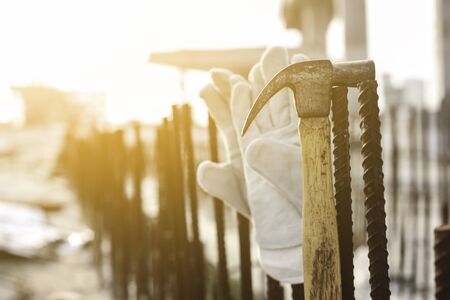 Leather safety gloves and hammer on construction working site background, Business construction concept.の写真素材